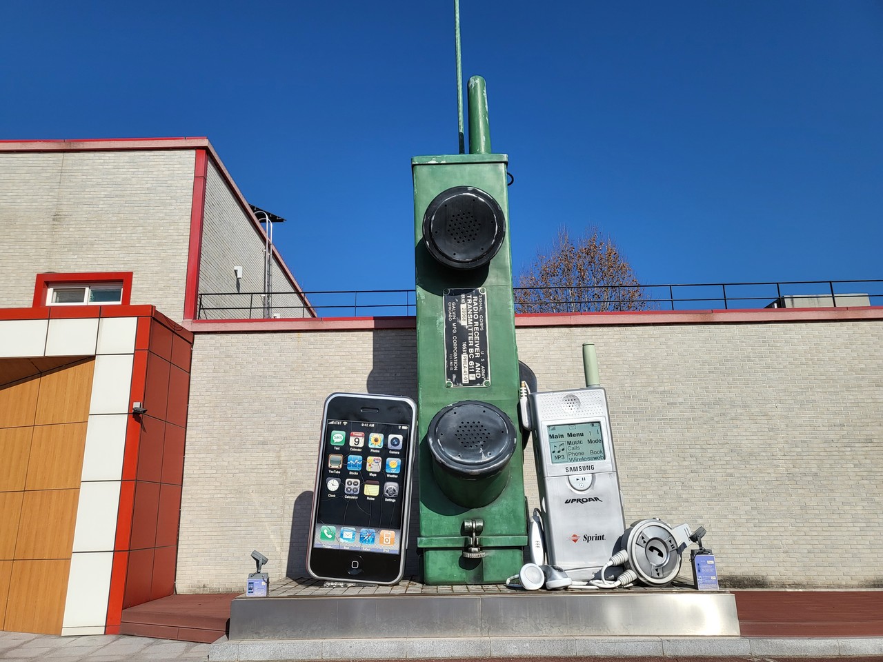 여주 시립 폰 박물관 앞에 안테나를 세운 거대한 벽돌폰과 왼쪽에는 아이폰, 오른쪽에는 삼성 구형폰 조형물이 크게 전시돼 있다.