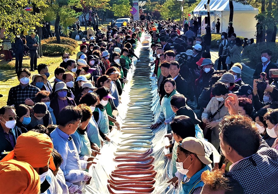 19일 이천농업테마공원에서 개최된 ‘제21회 이천쌀문화축제’에서 선보인 600m 길이 무지개 가래떡 이벤트에 참가한 시민들이 가래떡을 들어 보이고 있다. (사진=송석원 기자)