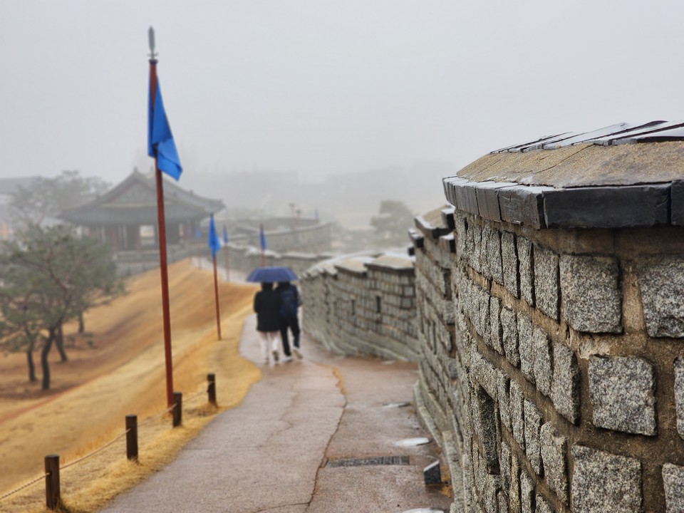 이슬비 내리는 수원화성 창룡문 성곽을 한 연인이 걷고 있다. 15일 수요일인 오늘 경기·인천지역은 구름이 많겠고, 약한 비 또는 빗방울이 떨어지겠다. (사진=중앙신문DB)