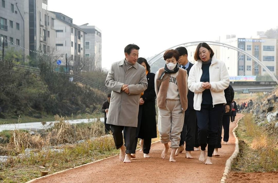 김동근 의정부시장이 민락천에 추가 연장 조성된 건강 황톳길 현장 답사에서 이곳을 찾은 지역 주민들과 함께 걷고 있다. (사진=김동근 의정부시장 페이스북)